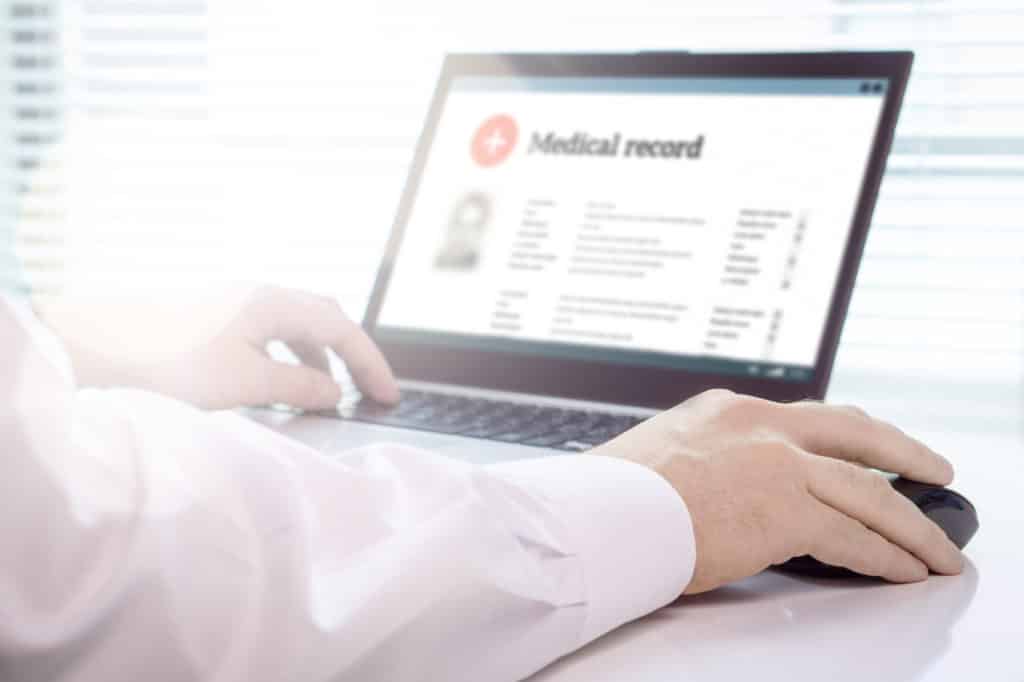 Doctor using laptop and electronic medical record (EMR) system.